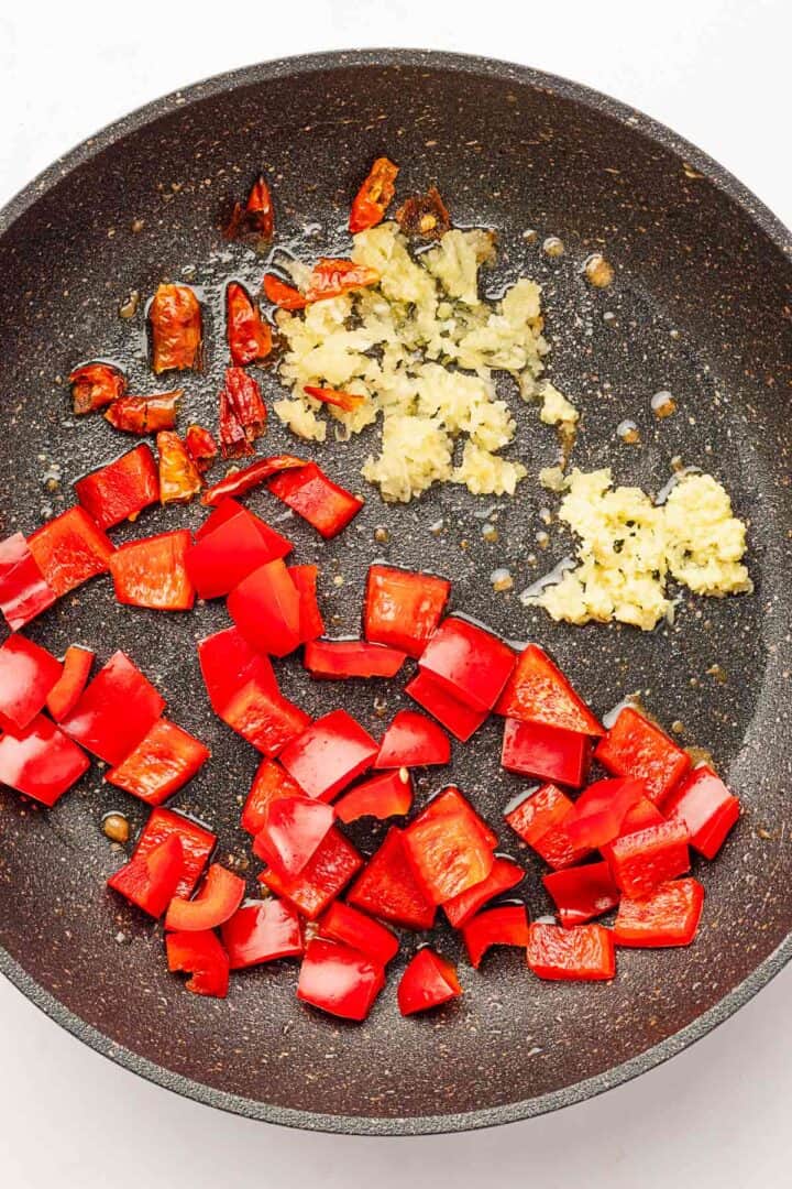 bell peppers, dried chili peppers and garlic in skillet.