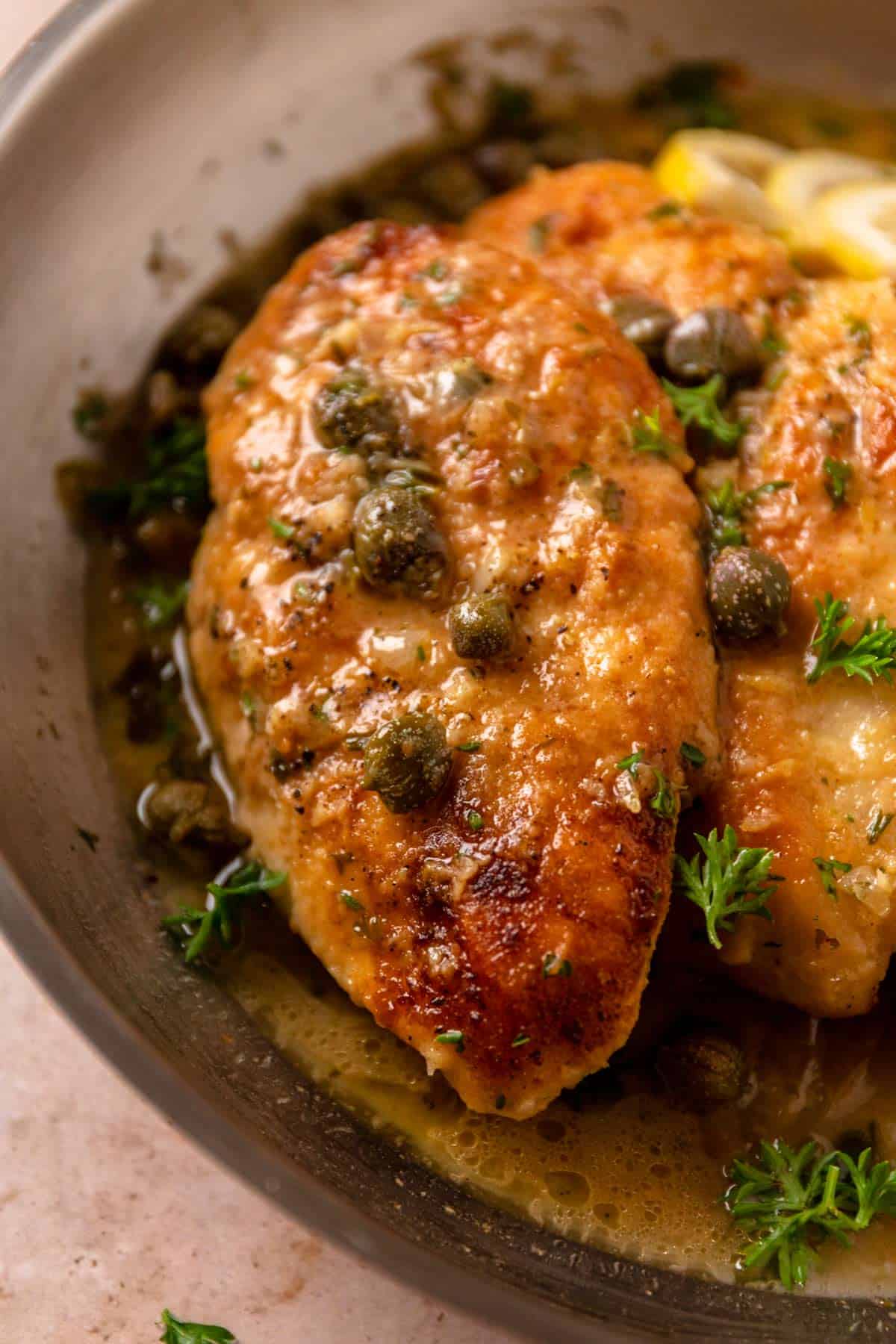gluten free piccata chicken cutlets with capers and lemon in a skillet