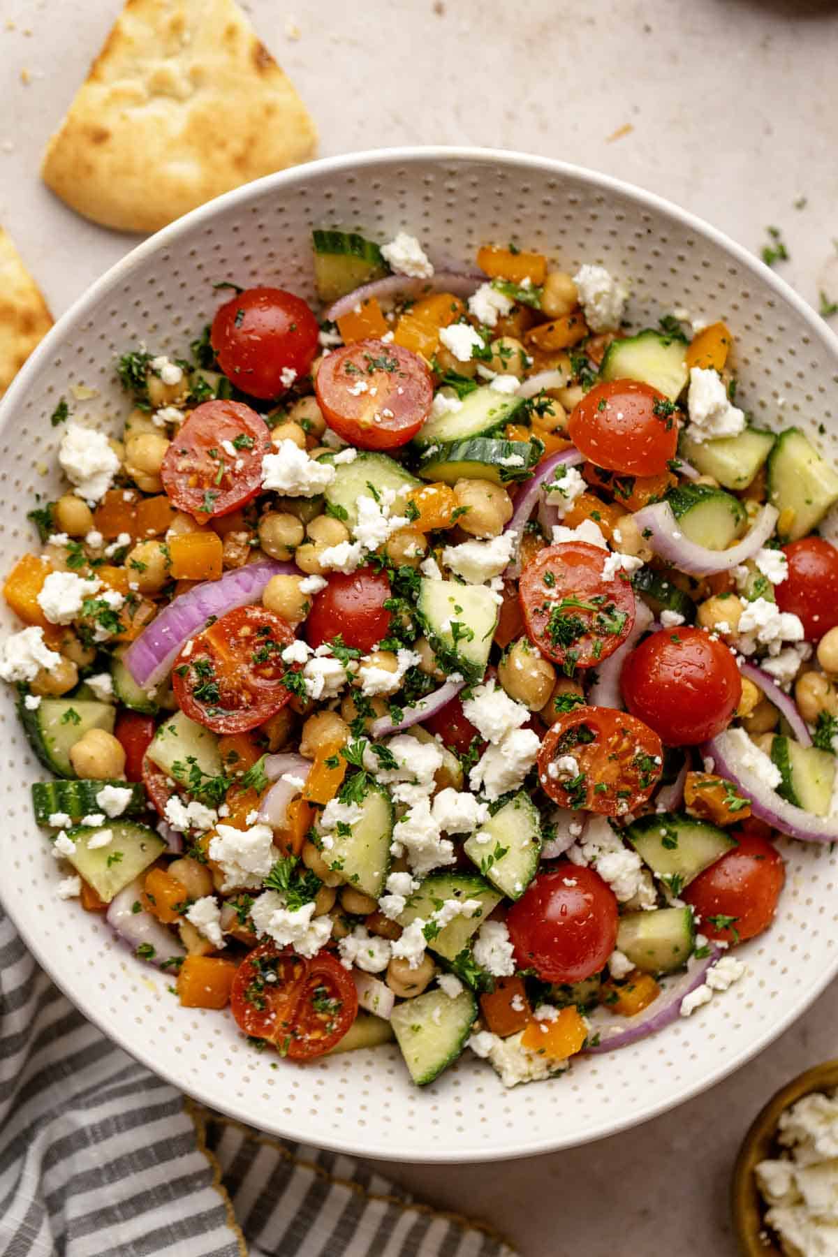 Mediterranean chickpea salad with vegetables and toasted pita bread.