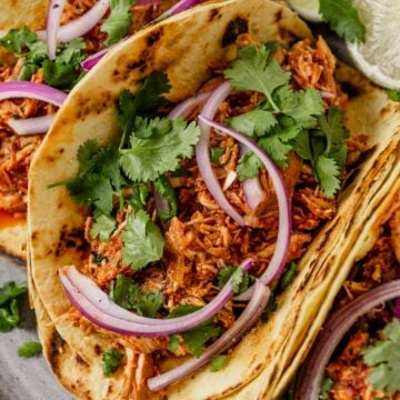 chicken tinga tacos with onion and cilantro on a plate