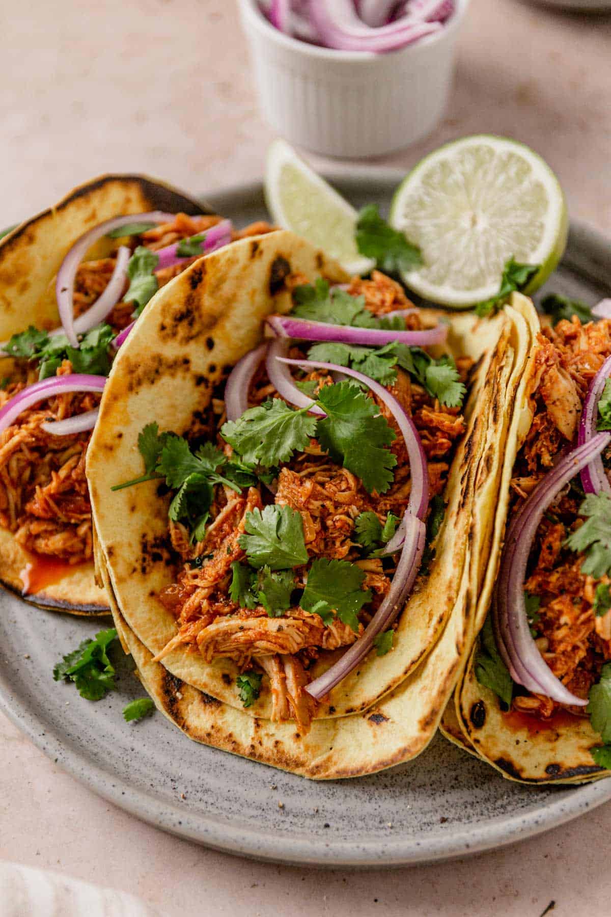 chicken tinga tacos with onion and cilantro on a plate