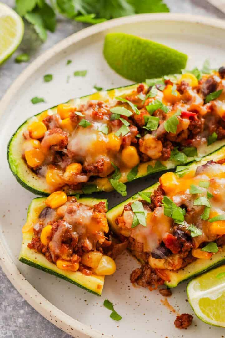 two stuffed zucchini taco boats on a plate.