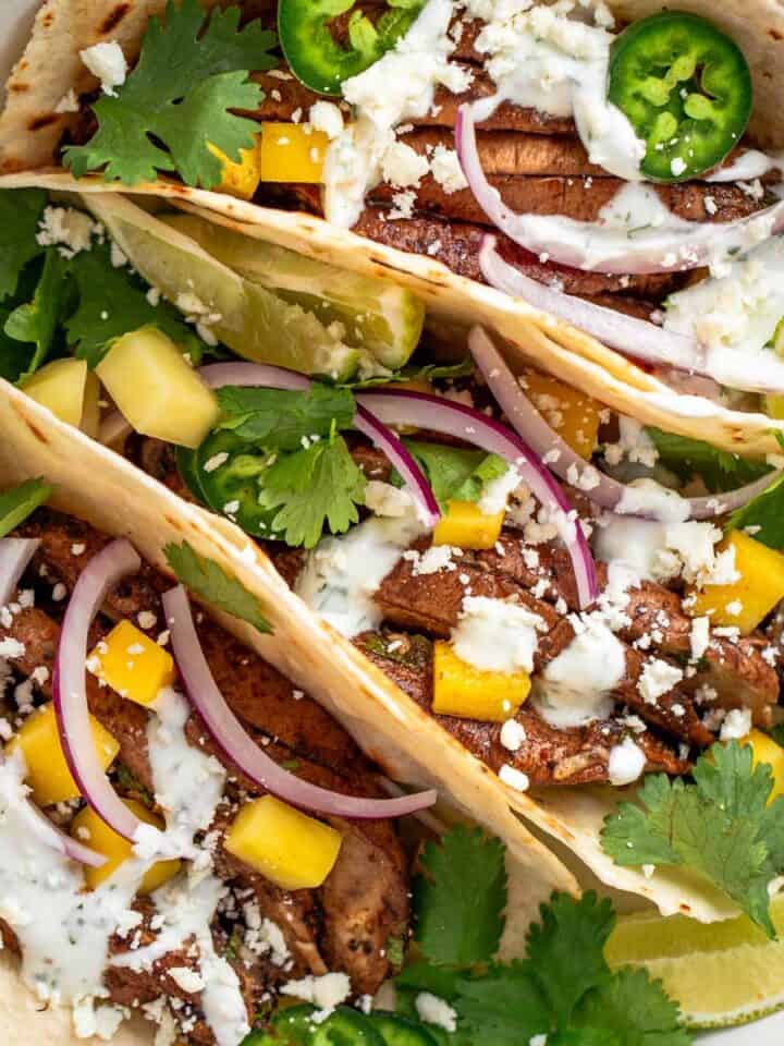 These smoky garlic mushroom tacos are quick, healthy, and full of flavor. Juicy portobellos, zesty lime, and a creamy cilantro sauce make this the perfect weeknight dinner!.