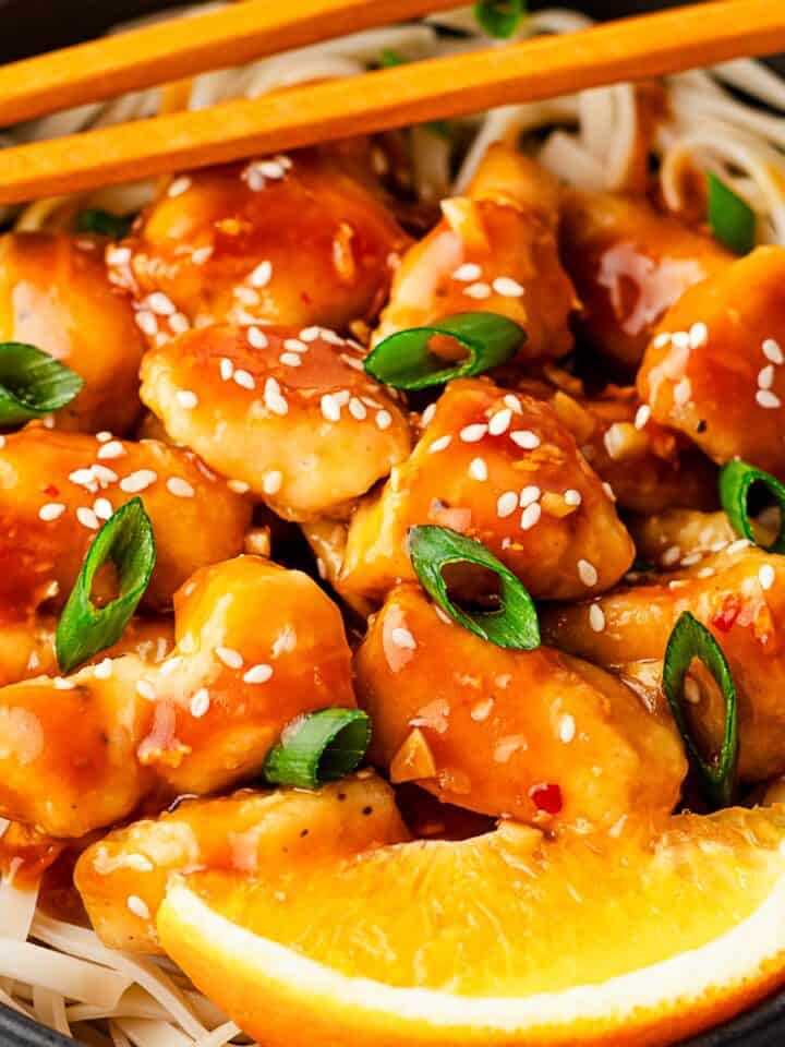 orange chicken with noodles and orange slices.