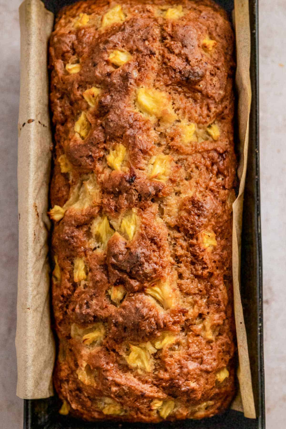 banana bread in loaf pan with pineapple on top