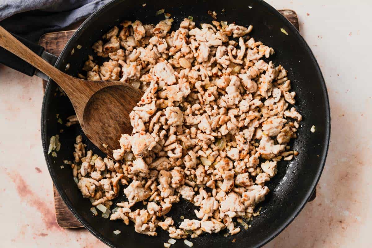 picture of ground chicken cooking in black skillet