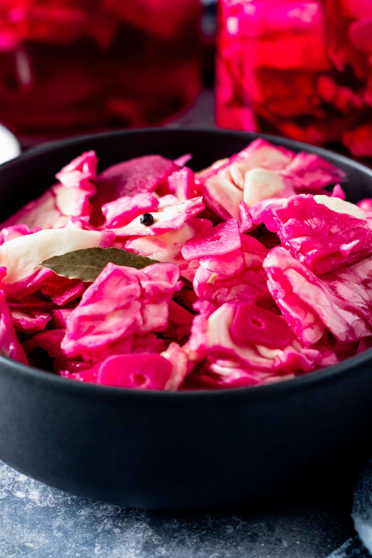pickled cabbage with beets in a black bowl.