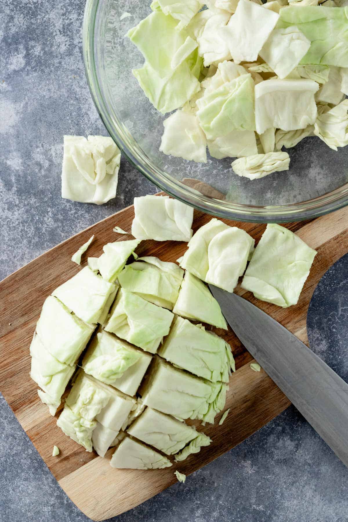 slicing the cabbage on a cutting board.