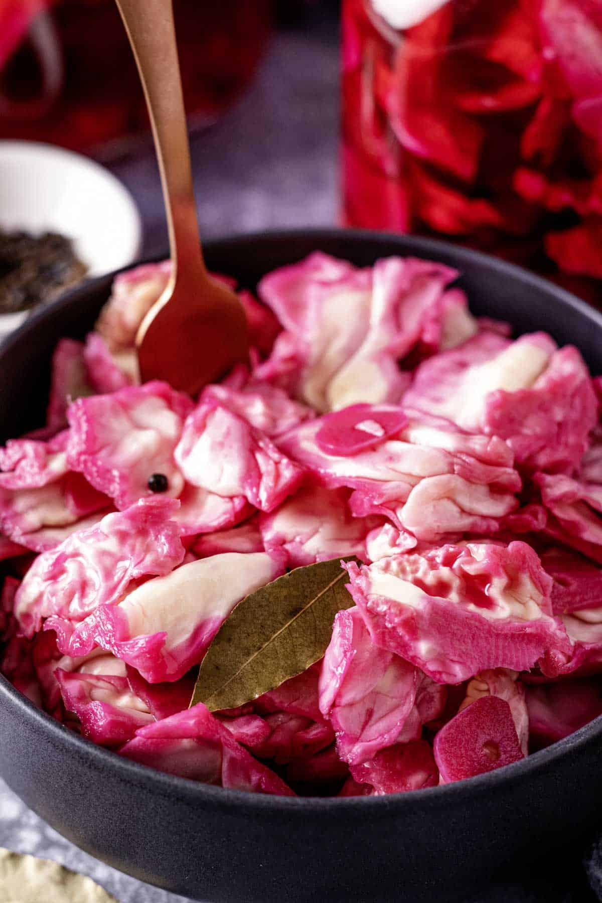crunchy pickled cabbage with beets in a black bowl.
