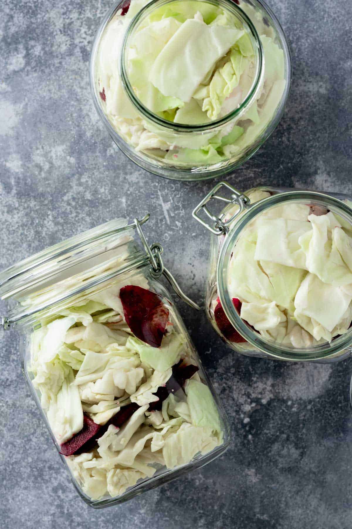 cabbage and beets stuffed in jars with pickling brine.