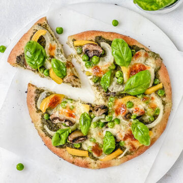 This 10-minute gluten free green pizza is healthy, vegetarian and perfect for Friday pizza night! It is made with my go-to homemade gluten free pizza dough recipe, topped with green basil pesto, mushrooms, bell pepper, mozzarella and fresh basil leaves. #greenpizza #glutenfreepizza #thickpizzacrust #glutenfreecrust #glutenfreegreenpizza #glutenfreepizzadough