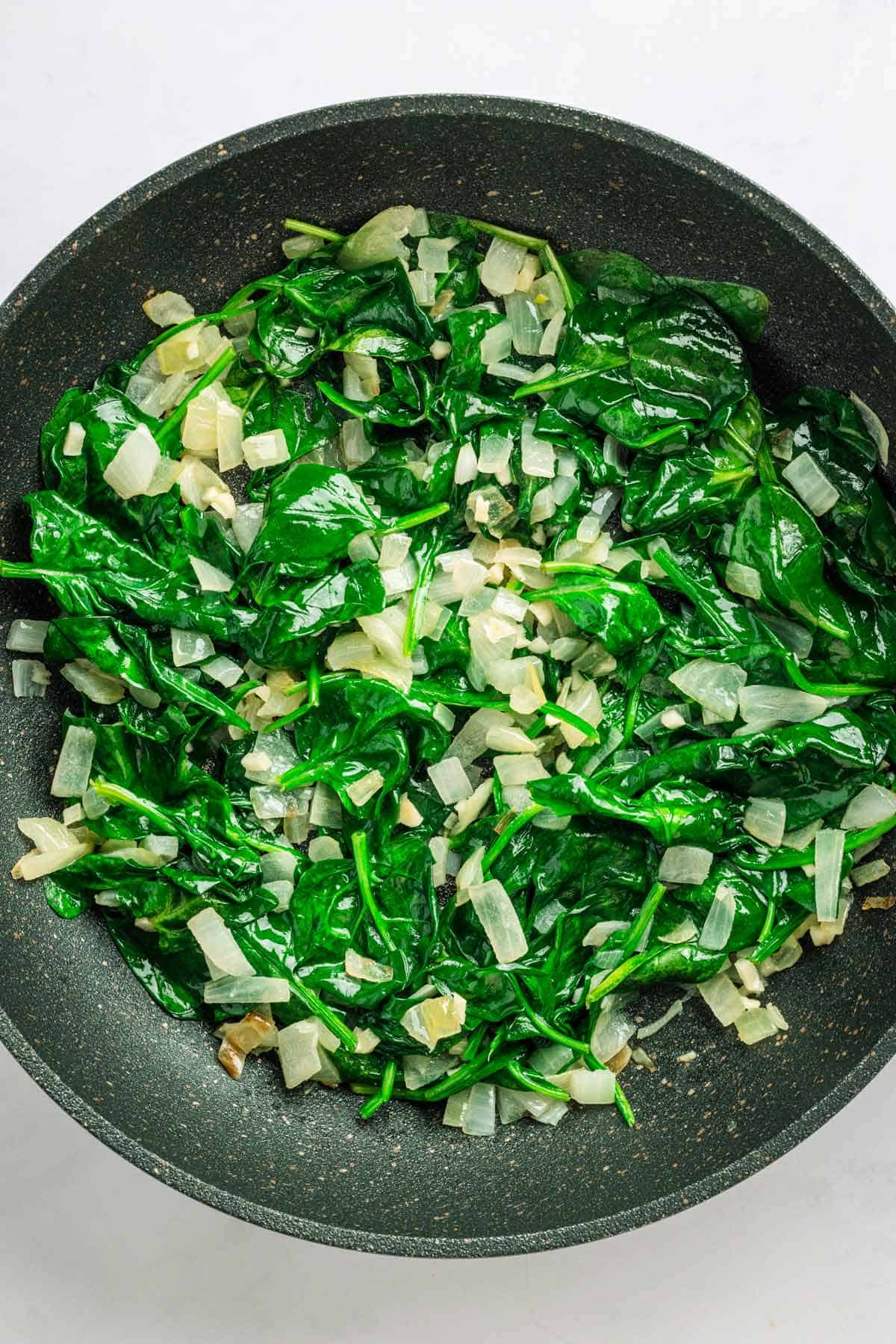 Sauteeing spinach for spinach potato casserole.