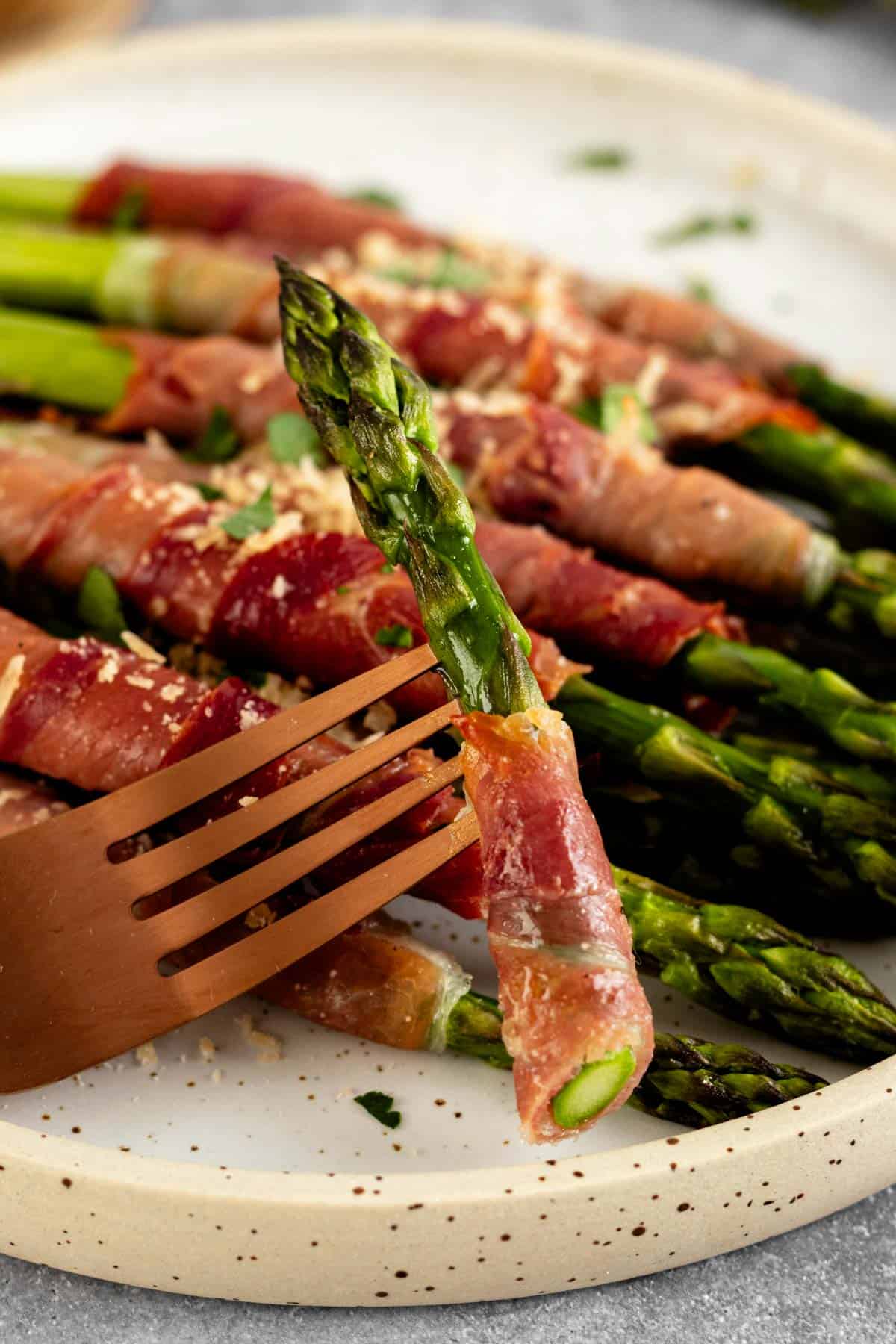 asparagus with prosciutto on a fork.