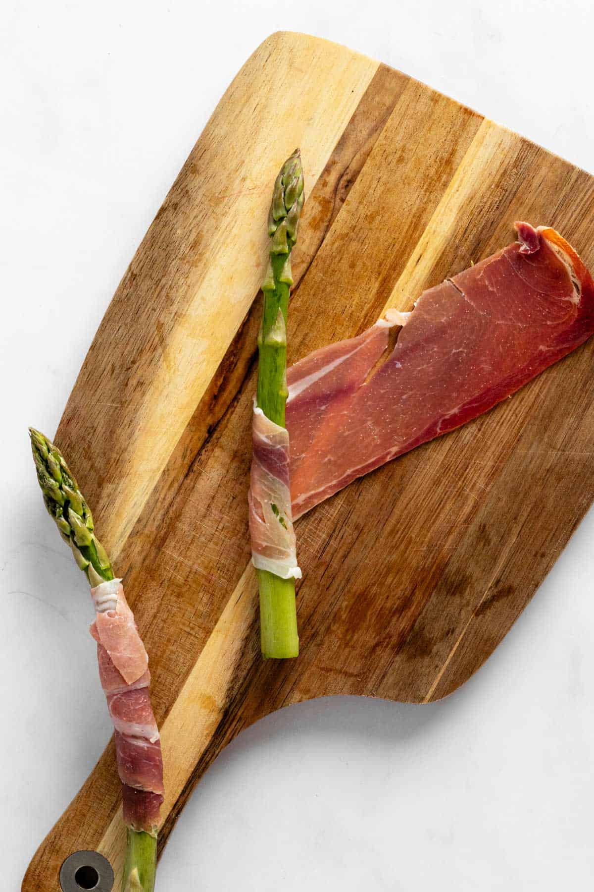 wrapping prosciutto slices around an asparagus stalk.