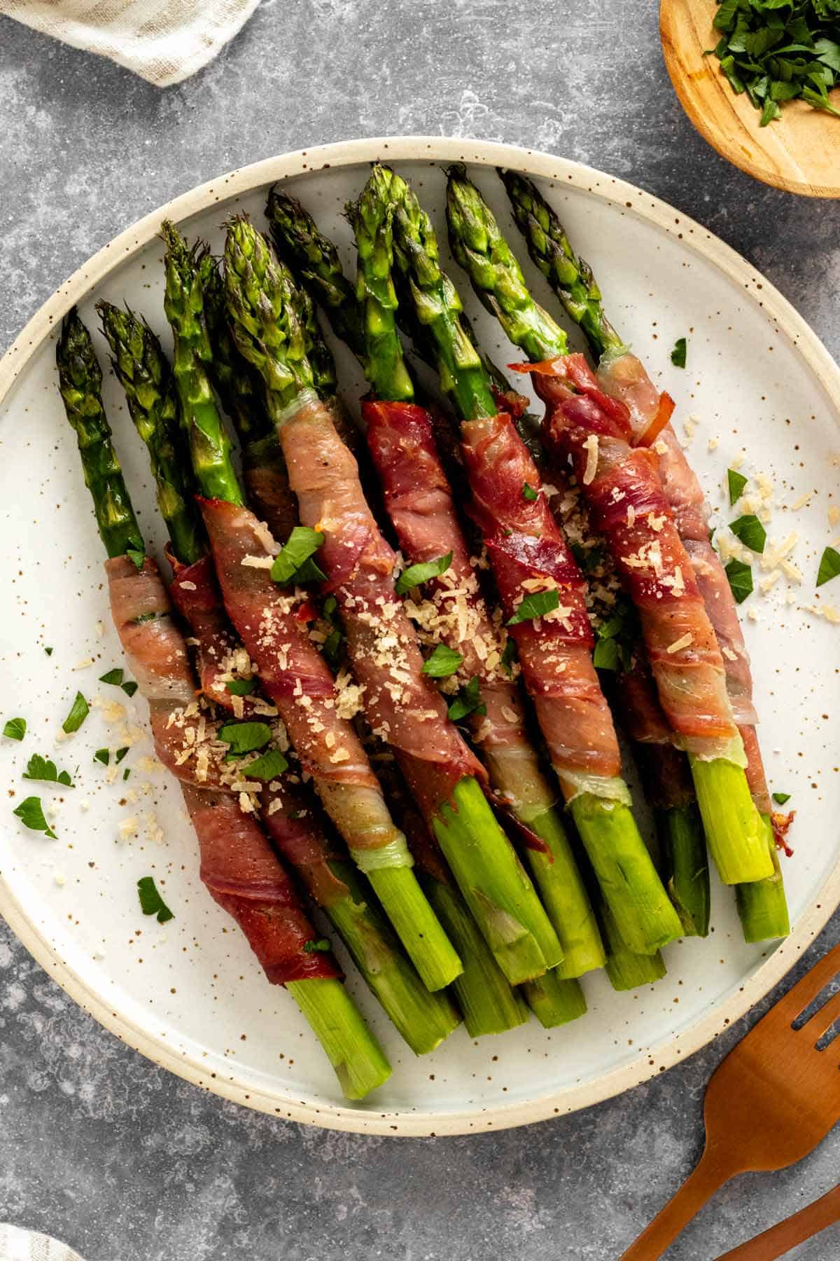 a plate of crispy prosciutto wrapped asparagus in oven.