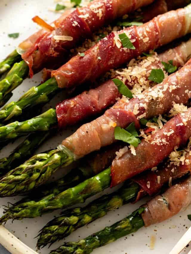 a plate of crispy prosciutto wrapped asparagus in oven.