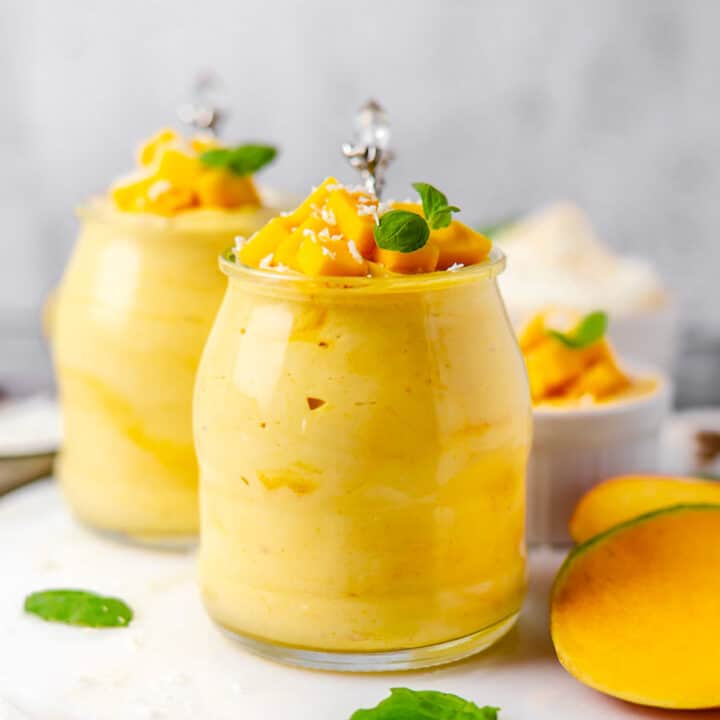 mango mousse in a glass with a spoon and mint bright photo