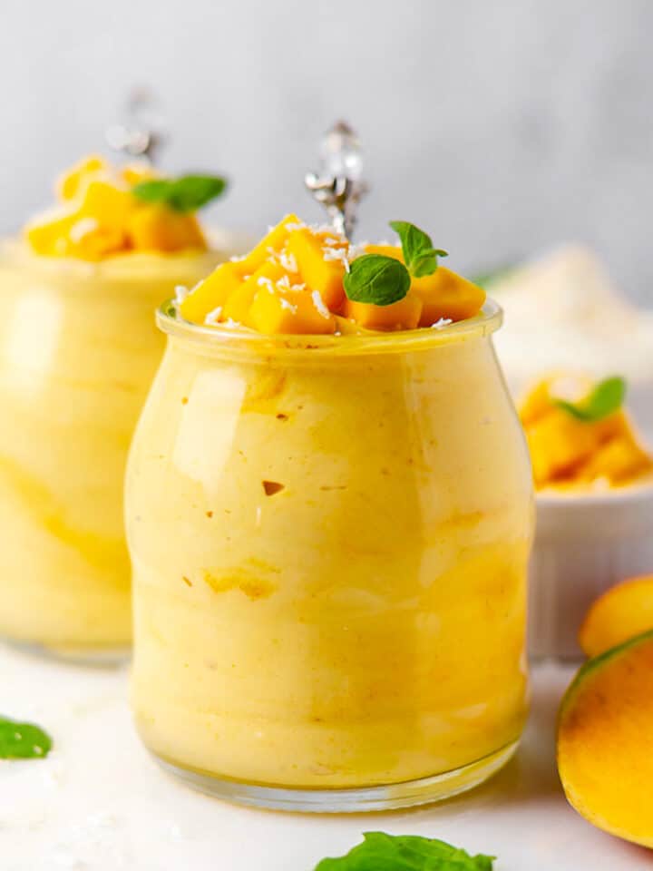 mango mousse in a glass with a spoon and mint bright photo