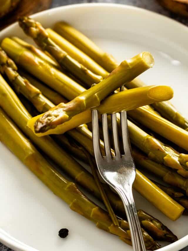 pickled asparagus spears on a plate.