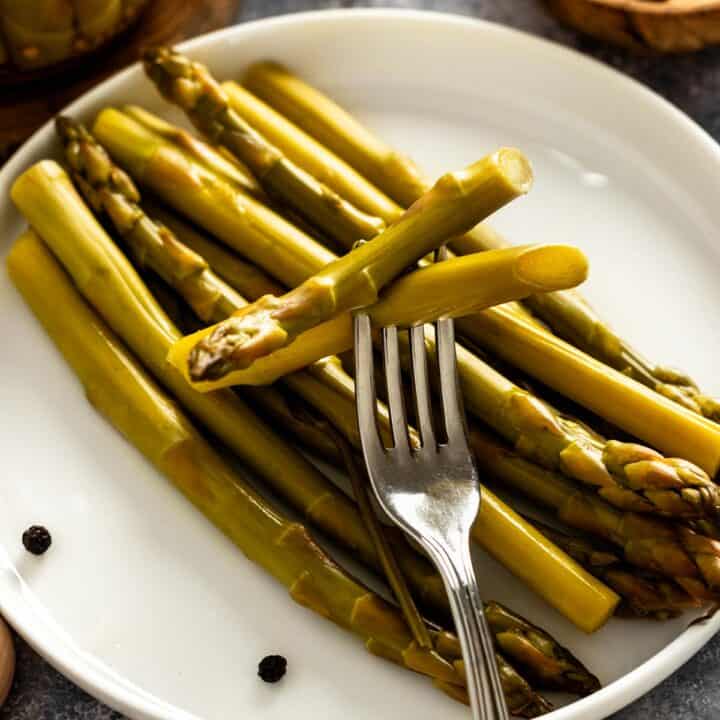 pickled asparagus spears on a plate.