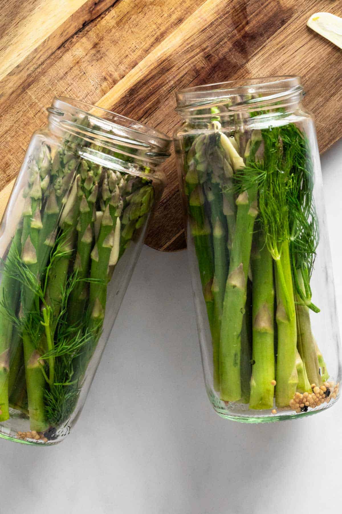 fresh asparagus spears in tall glass jar.
