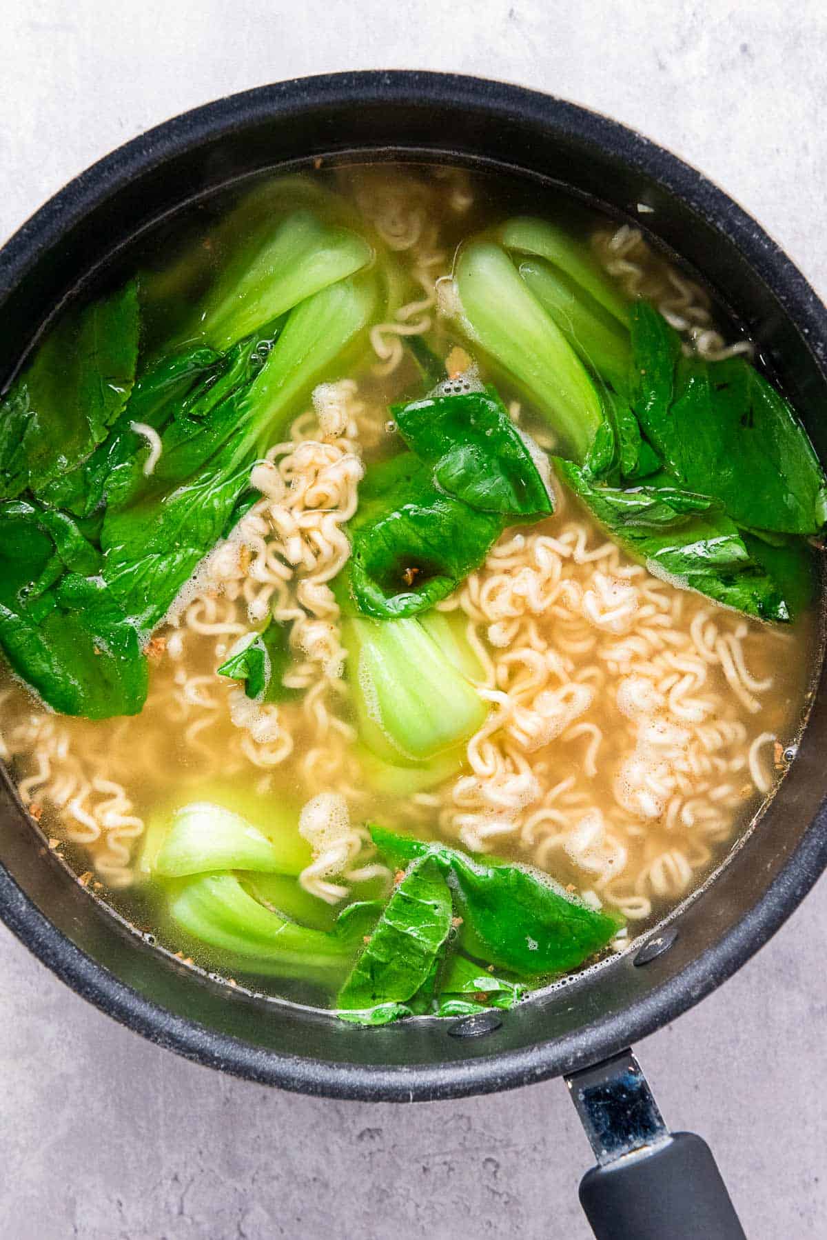 ramen noodles with bok choy in skillet.