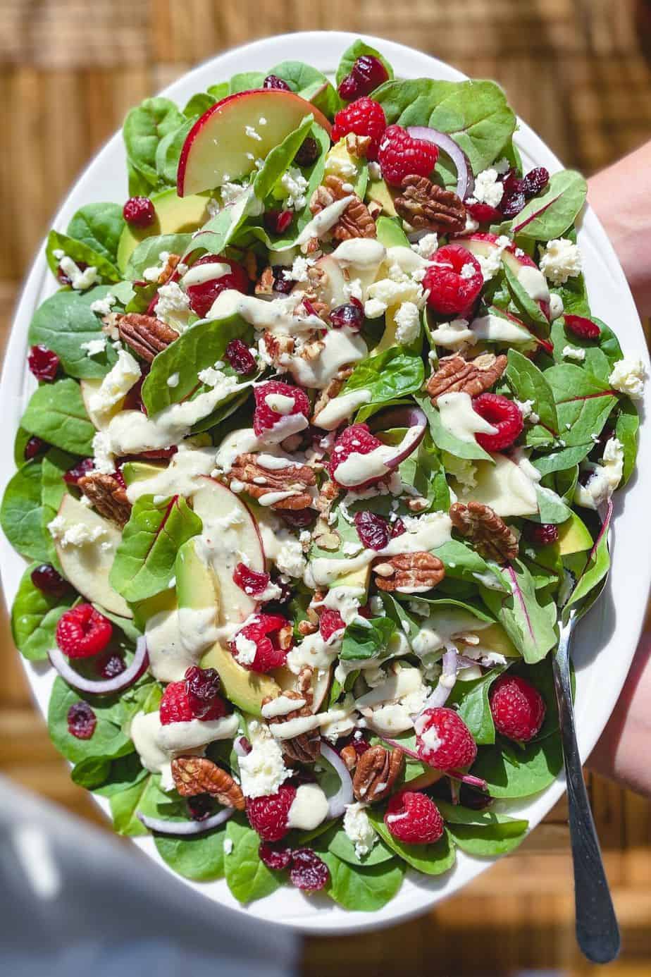 Raspberry, Spinach, and Beet Green Salad - healthy, summer salad recipe loaded with raspberries, pecans, fresh spinach, feta, and beet leaves. This recipe uses just a few ingredients and is simply delicious on its own. But what makes this salad unforgettably delicious is the Creamy Greek Yogurt Herb Dressing. - The Yummy Bowl