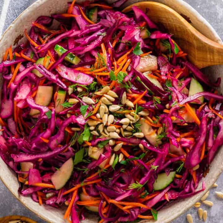 a bowl of red cabbage salad with dressing.