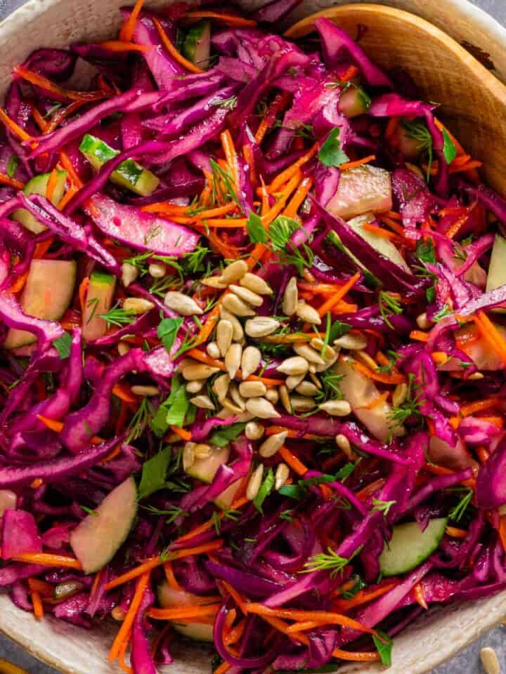 a bowl of red cabbage salad with dressing.