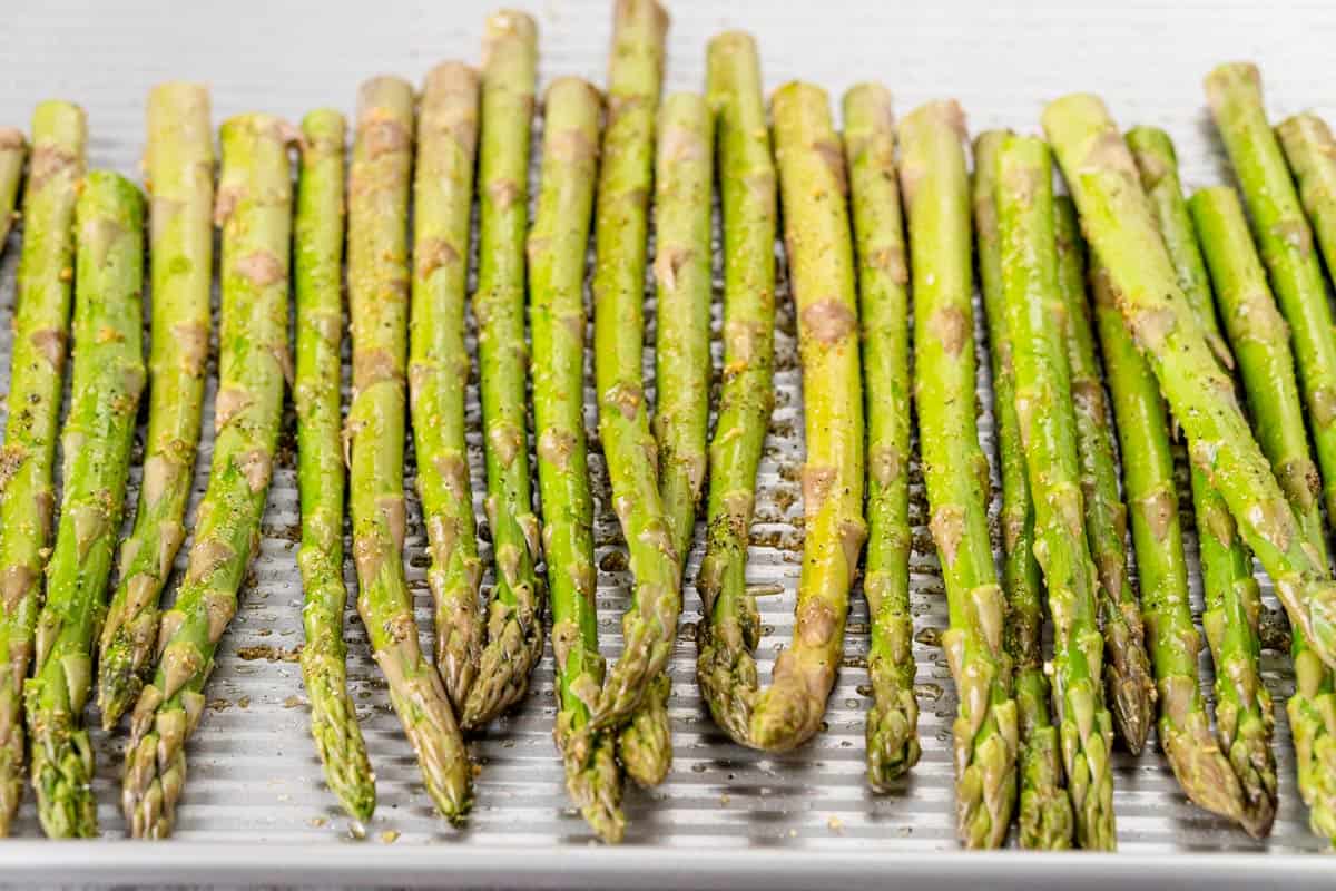 seasoned asparagus sprigs on baking sheet