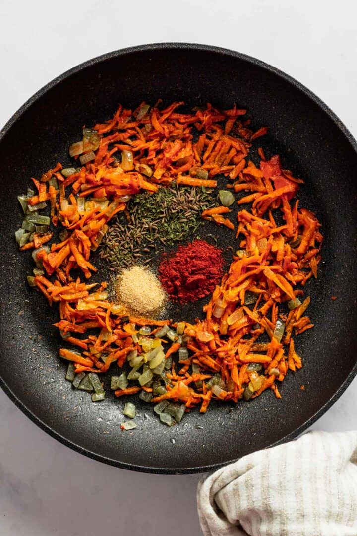 adding aromatics and spices to carrot skillet.