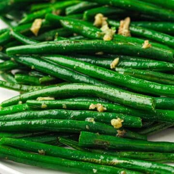 Green beans seasoned with salt and pepper in a skillet.