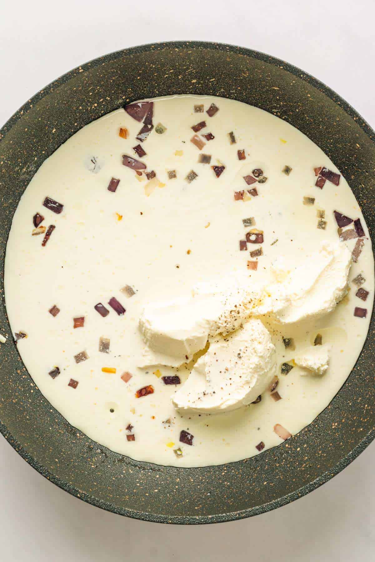 Making the creamy sauce in skillet for Spinach Gratin.