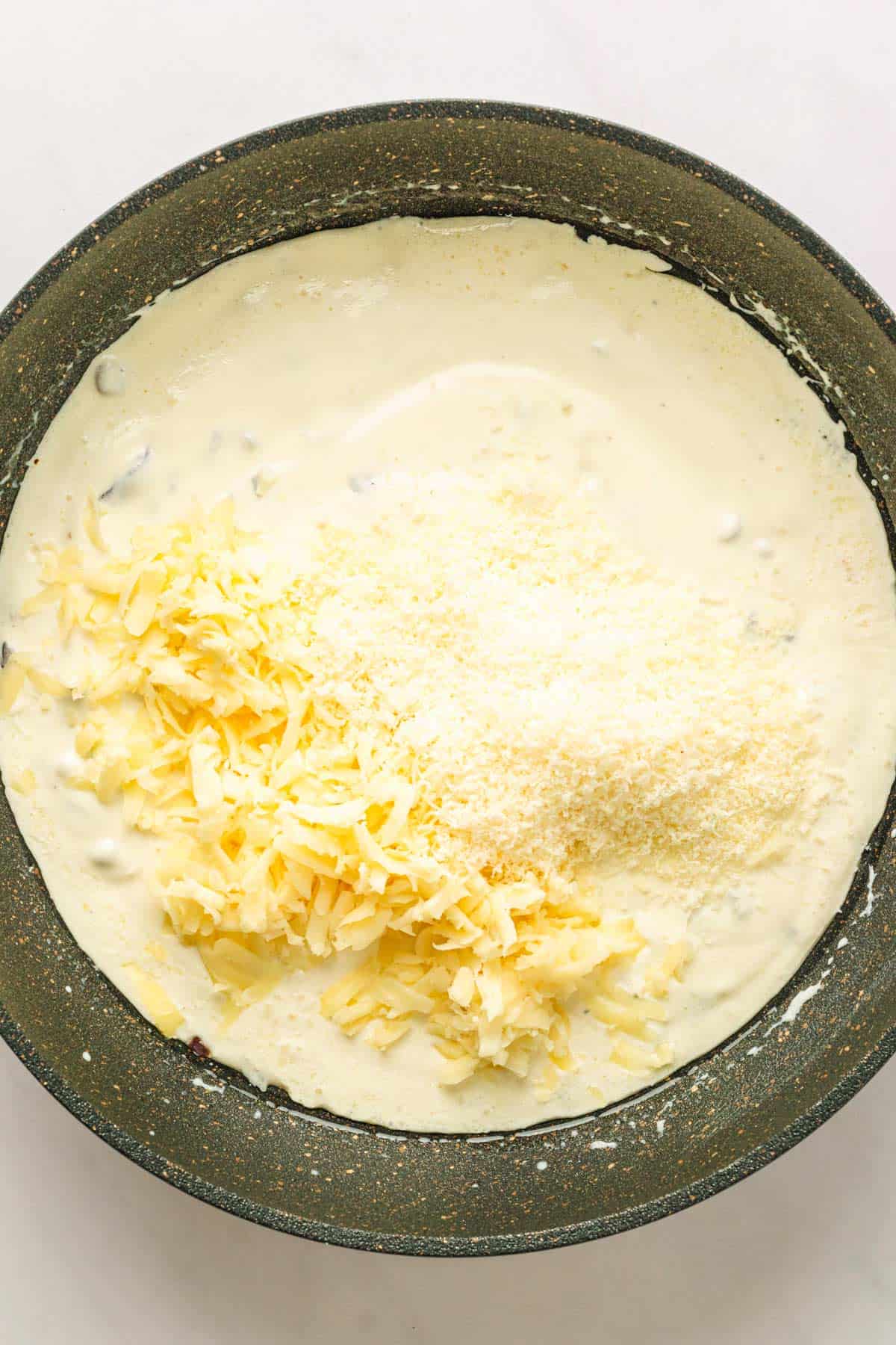 Making the creamy sauce in skillet for Spinach Gratin.