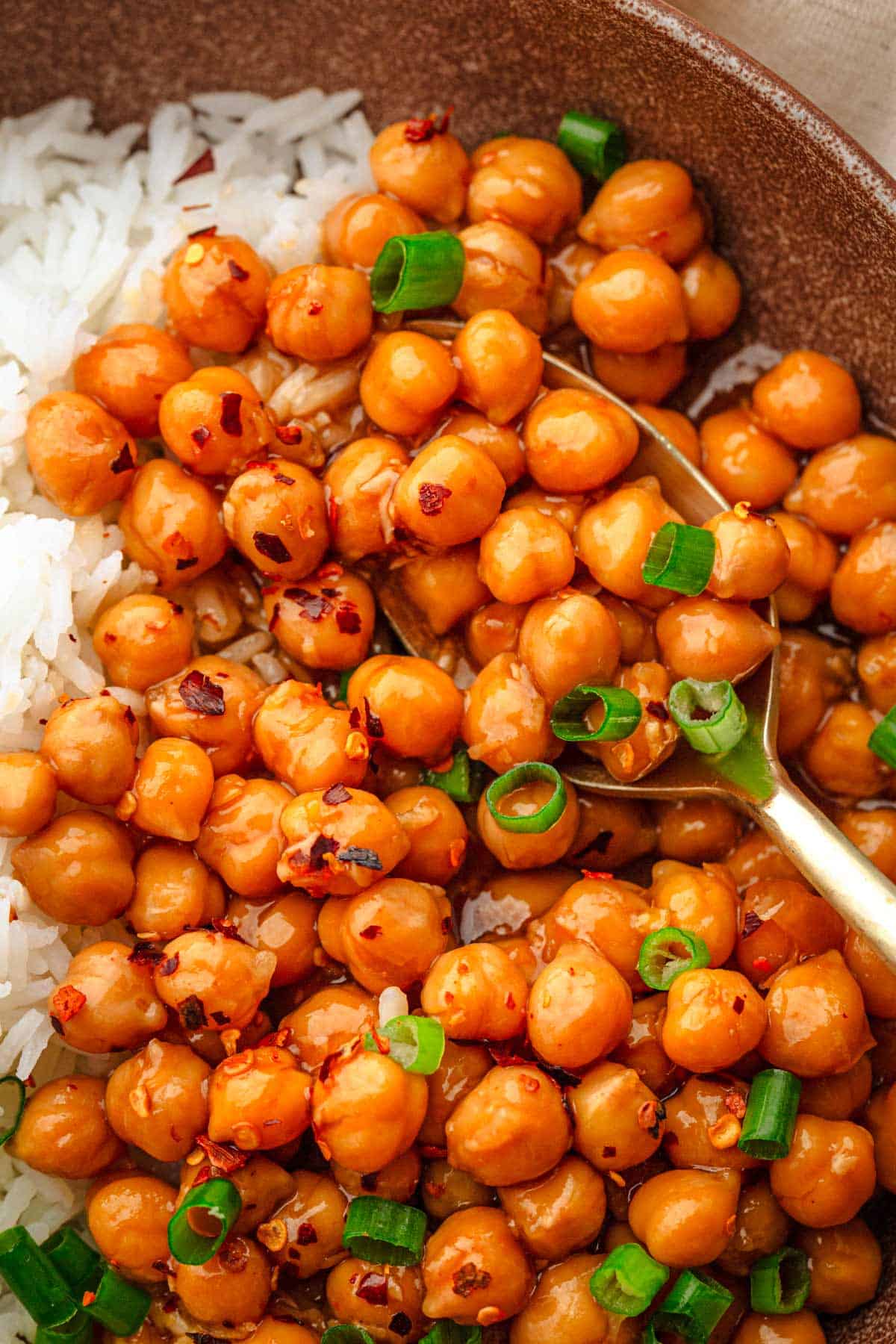 Sticky sesame chickpeas with rice and lime wedges.