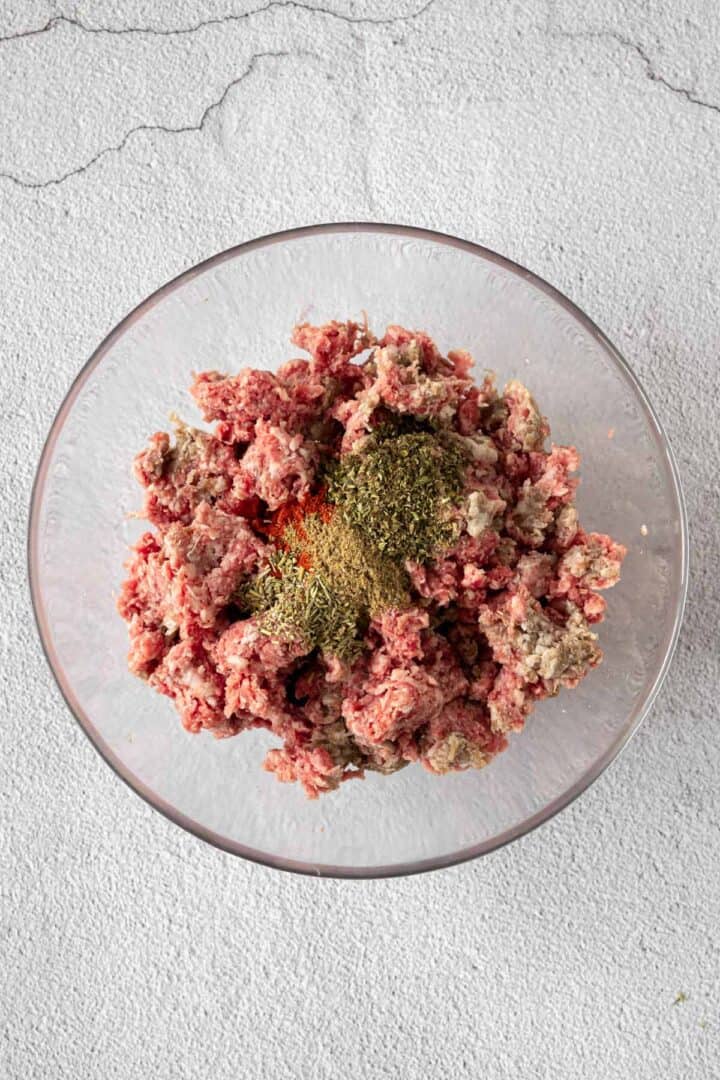 mixing the ground beef with seasonings.