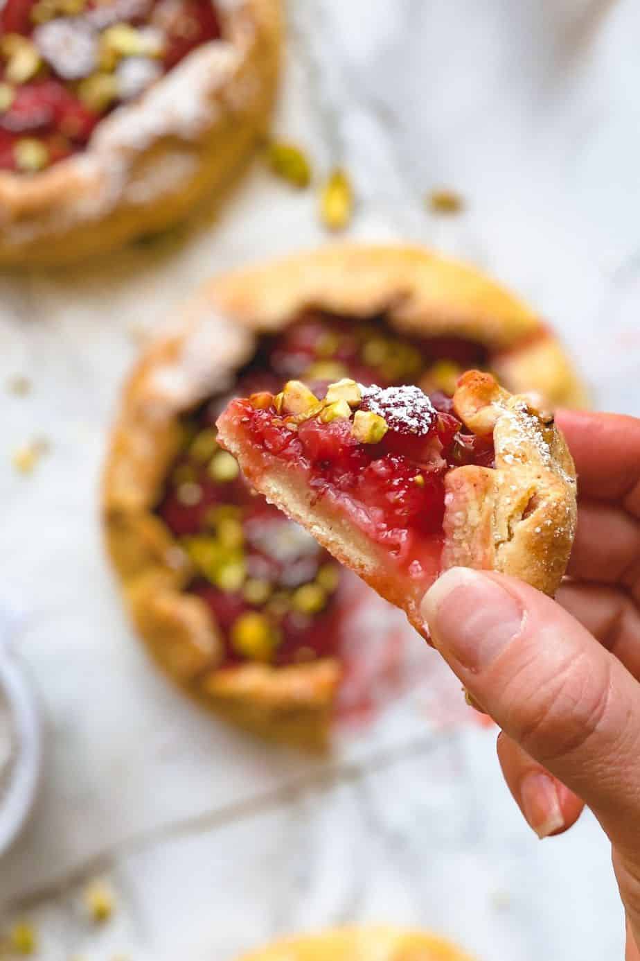 Strawberry pistachio galettes - The easiest and most delicious strawberry dessert recipe. These min yummy strawberry pies are made with cottage cheese, fresh strawberries and topped with crushed pistachios. Simply the best and easiest homemade mini pie recipe that no one cant resist. - The Yummy Bowl