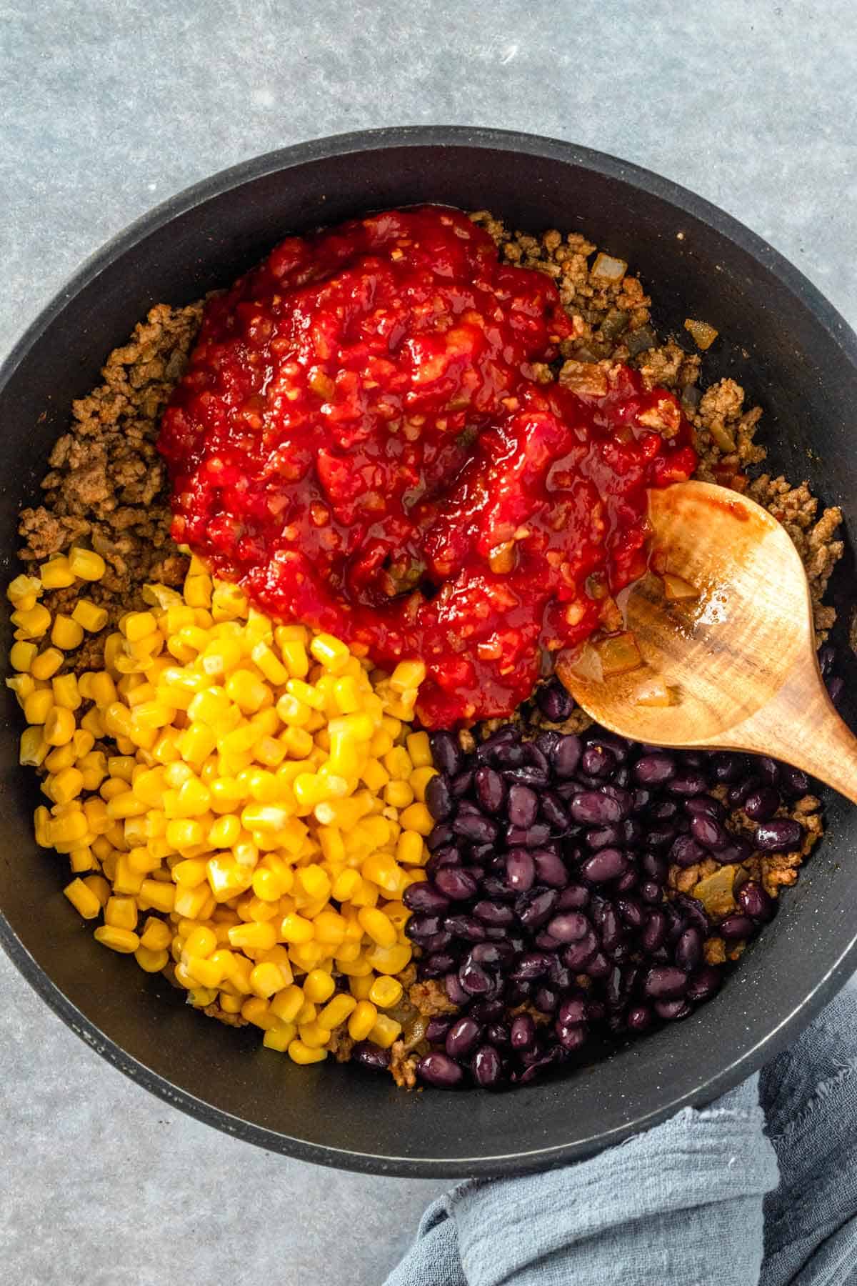 tomato sauce, corn, black beans and ground beef in skillet before cooking