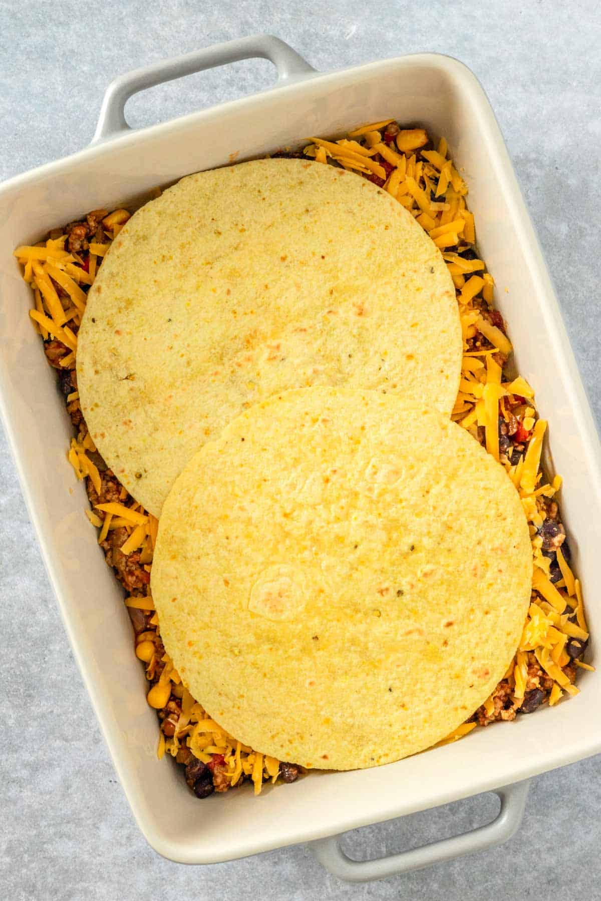 layers of beef mixture, cheddar cheese and tortillas in casserole dish