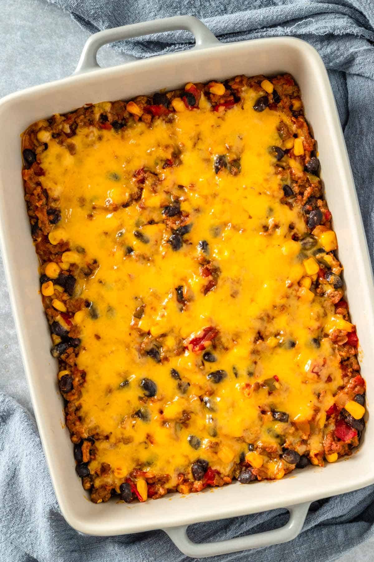 taco casserole with melted cheese on top in casserole dish