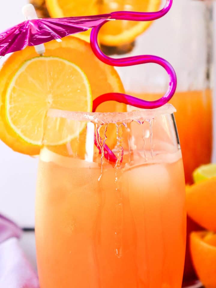 tequila sunrise mocktail in a glass with decorations.