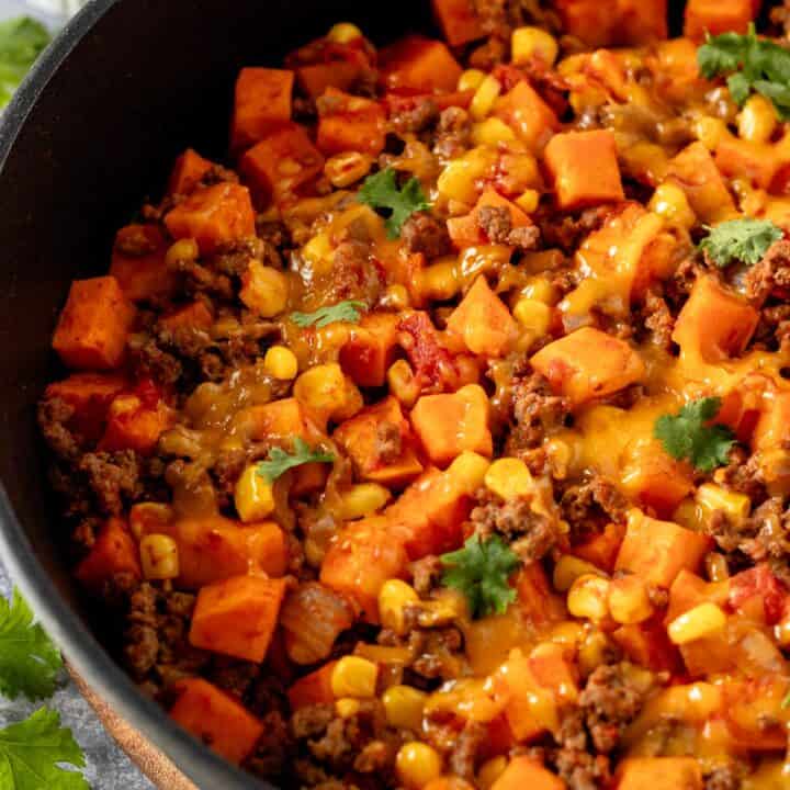 ground beef and sweet potatoes in skillet with cheese.