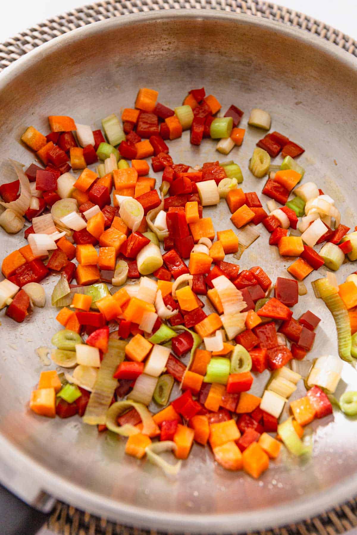 carrot, scallions and bell peppers sauteing in skillet