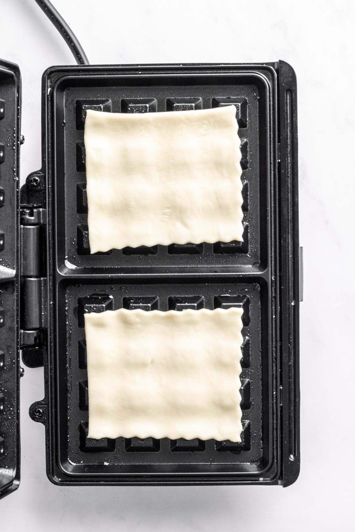 Puff pastry sheets in waffle maker.