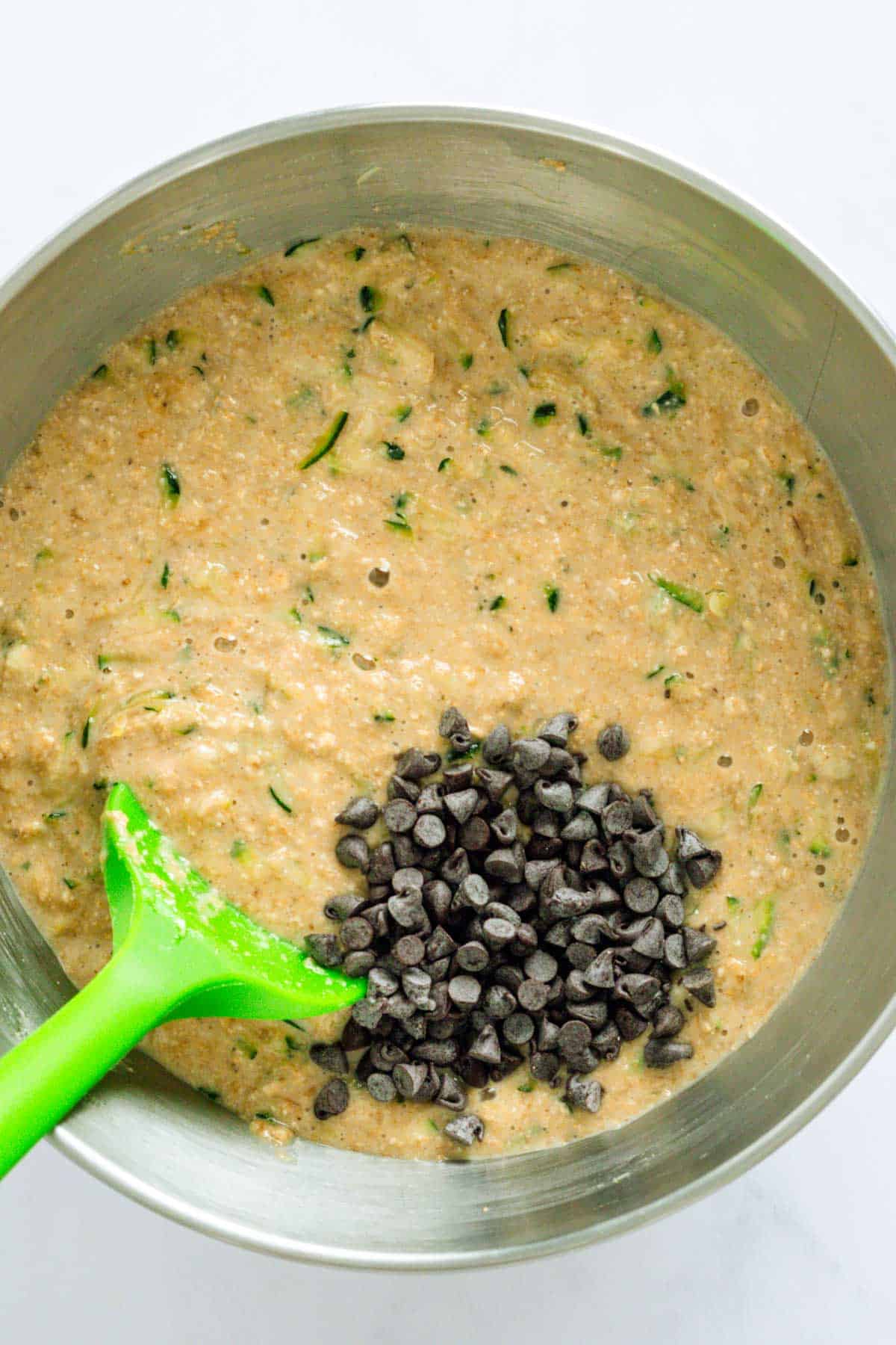 adding chocolate chips to zucchini muffin batter.